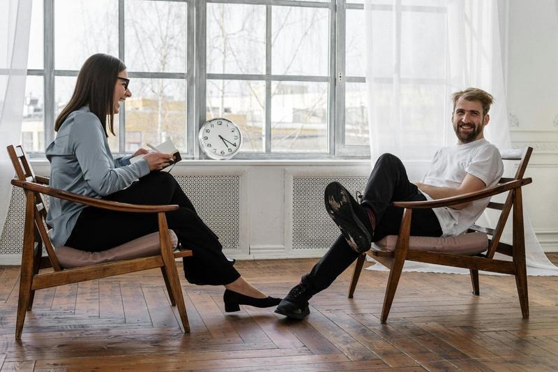 alt="Smiling therapist and client in conversation"